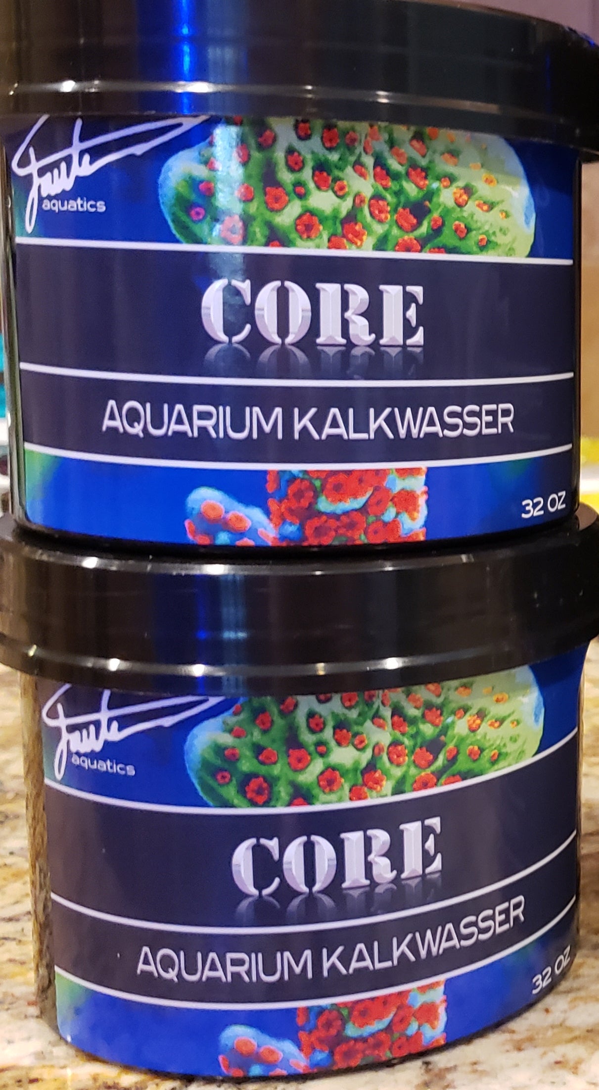 Two cans of CORE Aquarium Kalkwasser by Fauth Aquatics, each can has a capacity of 32oz and is labeled with the brand and product name.
