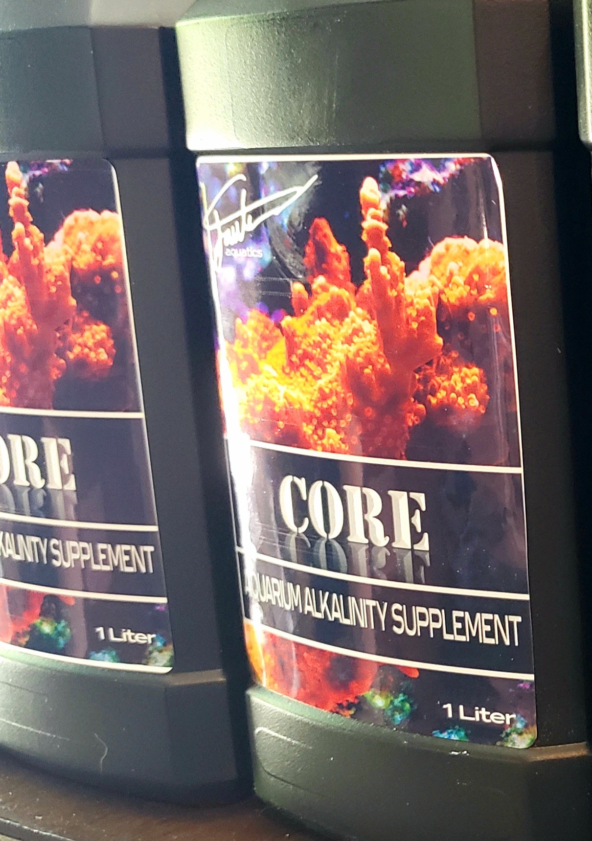 Two bottles of CORE Alkalinity supplement by Fauth Aquatics, each containing 1 liter of the product, with coral imagery on the labels.