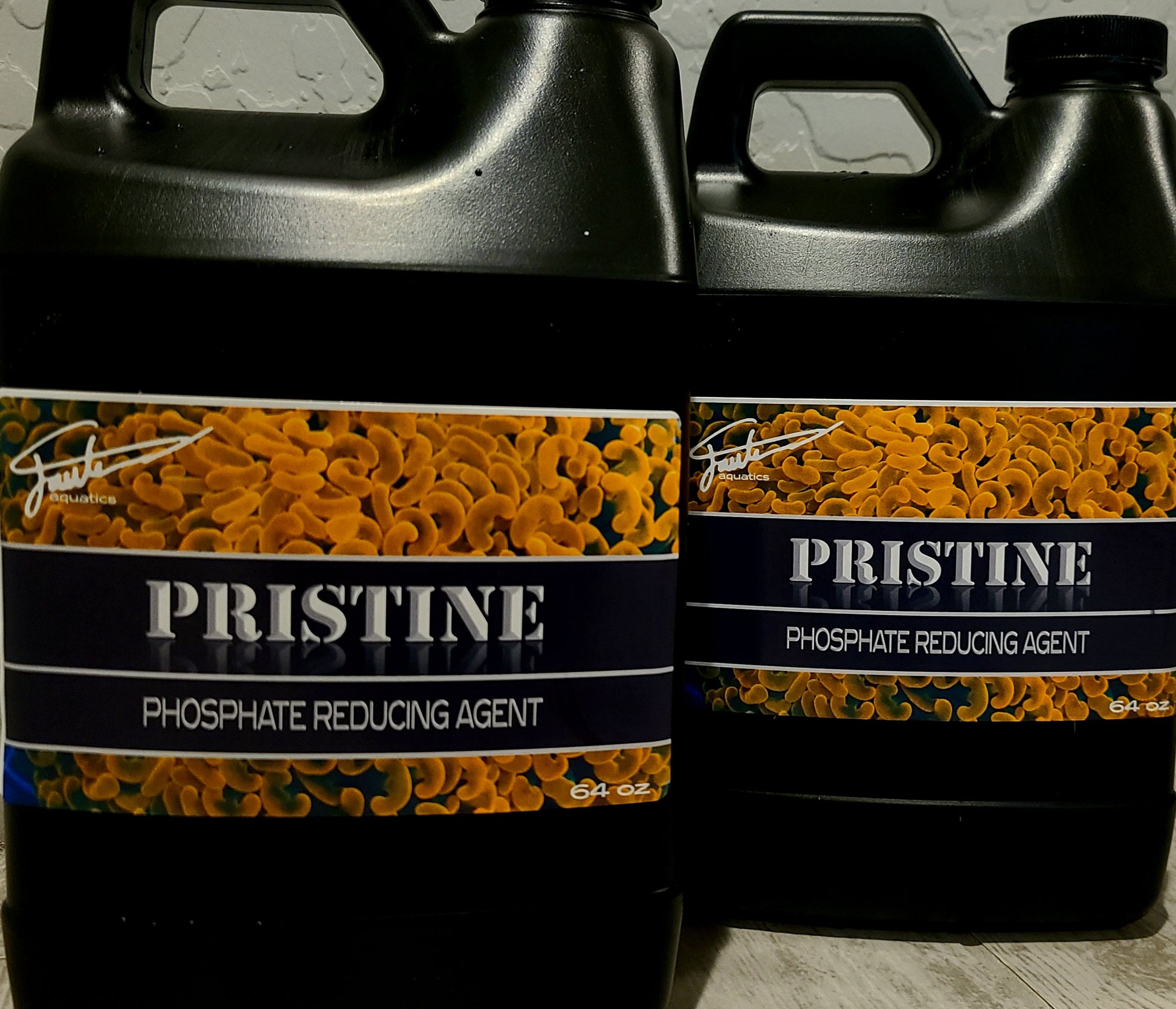 Two black plastic jugs with orange and white labels reading 'PRISTINE PHOSPHATE REDUCING AGENT'.