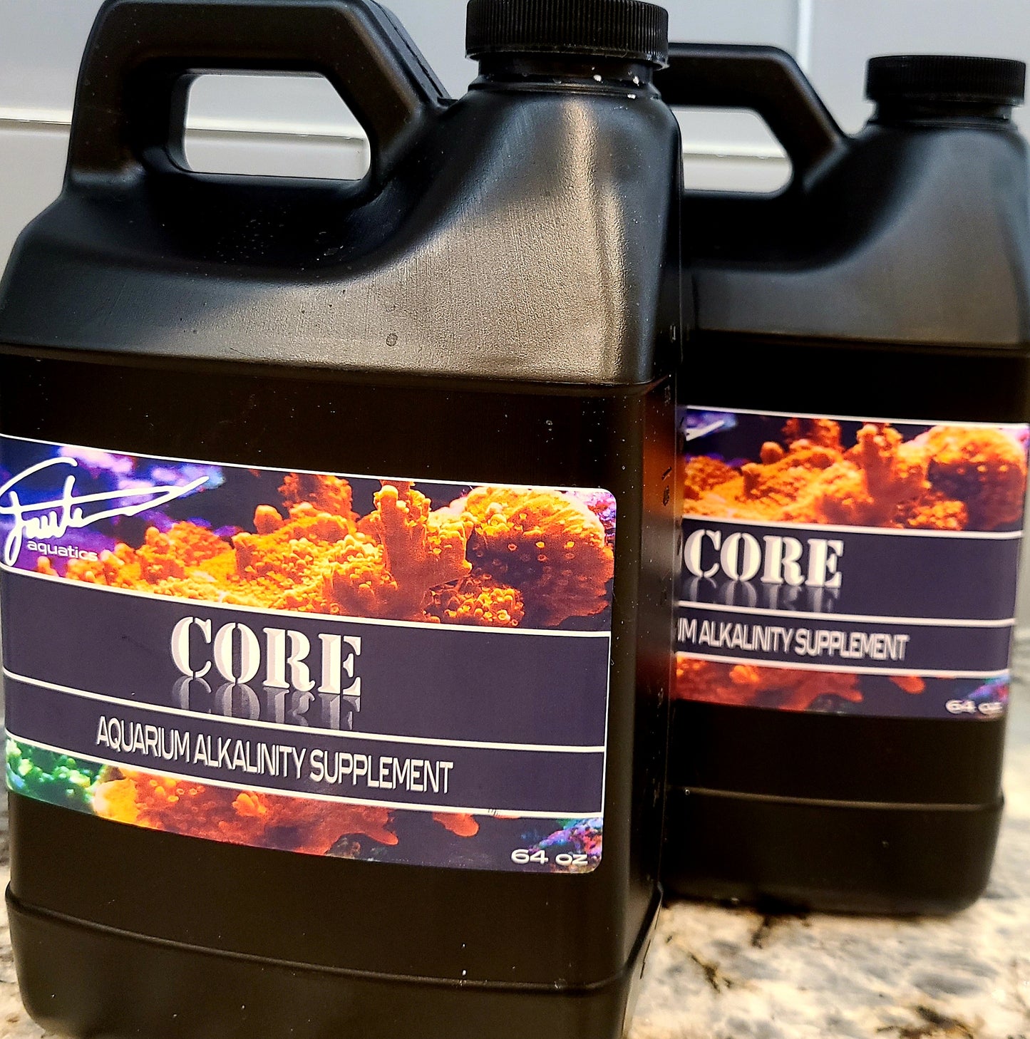 Two black plastic bottles of CORE Alkalinity aquarium supplement by Fauth Aquatics, with labels showing coral imagery.