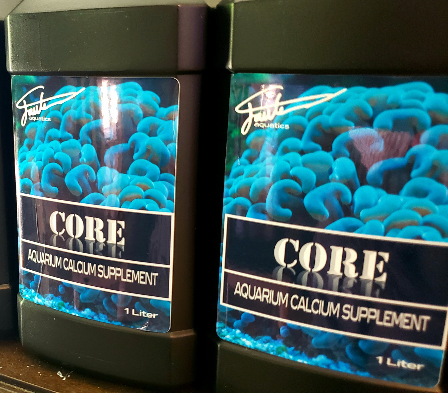 Two bottles of CORE aquarium calcium supplement by Fauth Aquatics, each containing 1 liter of the solution, with a label showing a close-up image of blue coral.