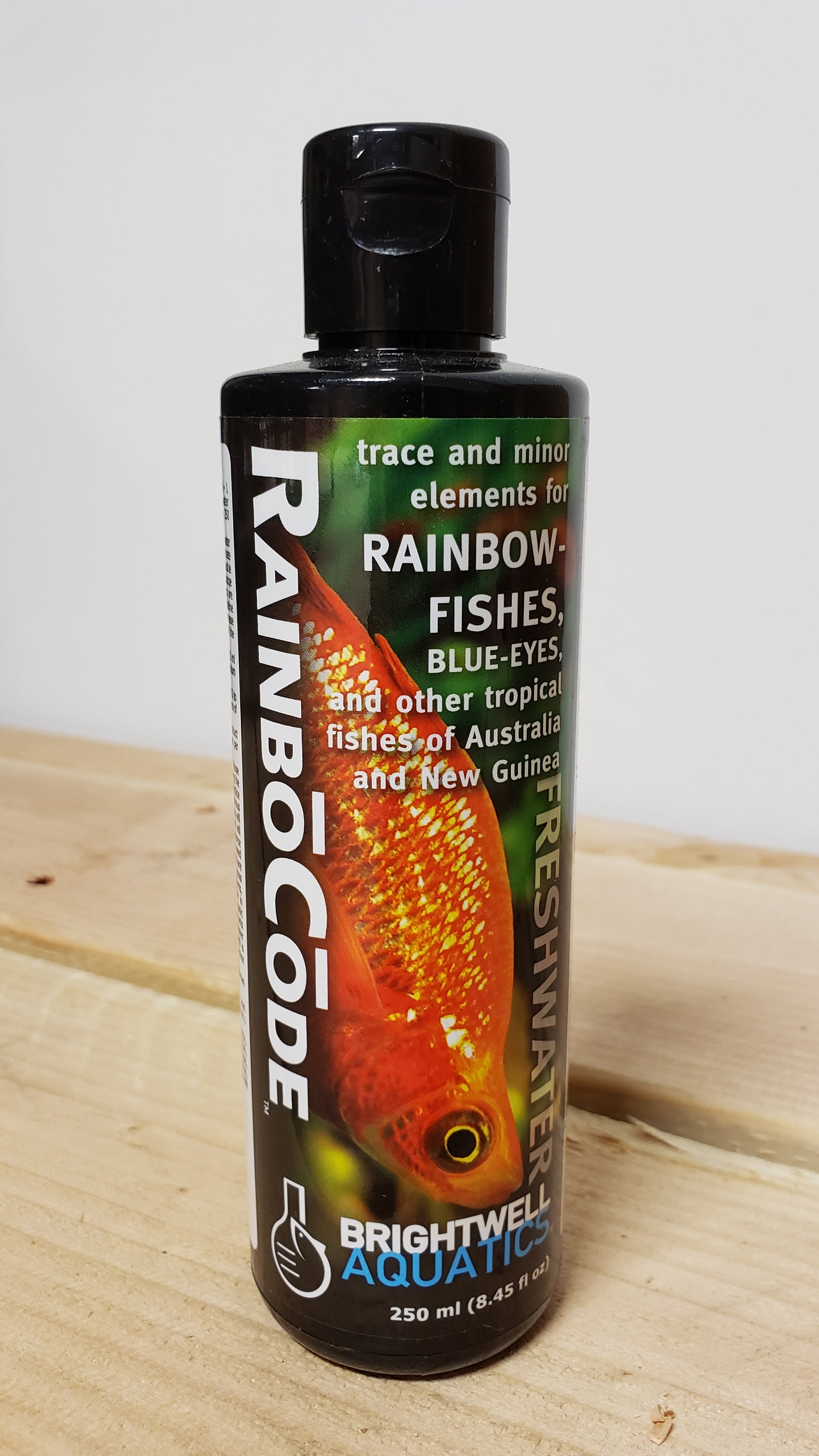 This image features a 250ml bottle of Brightwell Rainbo Code, a specialized aquatic product designed for trace and minor element correction in rainbow fish and other tropical fish. The bottle is prominently labeled with the product name and has a vivid image of a rainbow fish on it, emphasizing its use and target species.