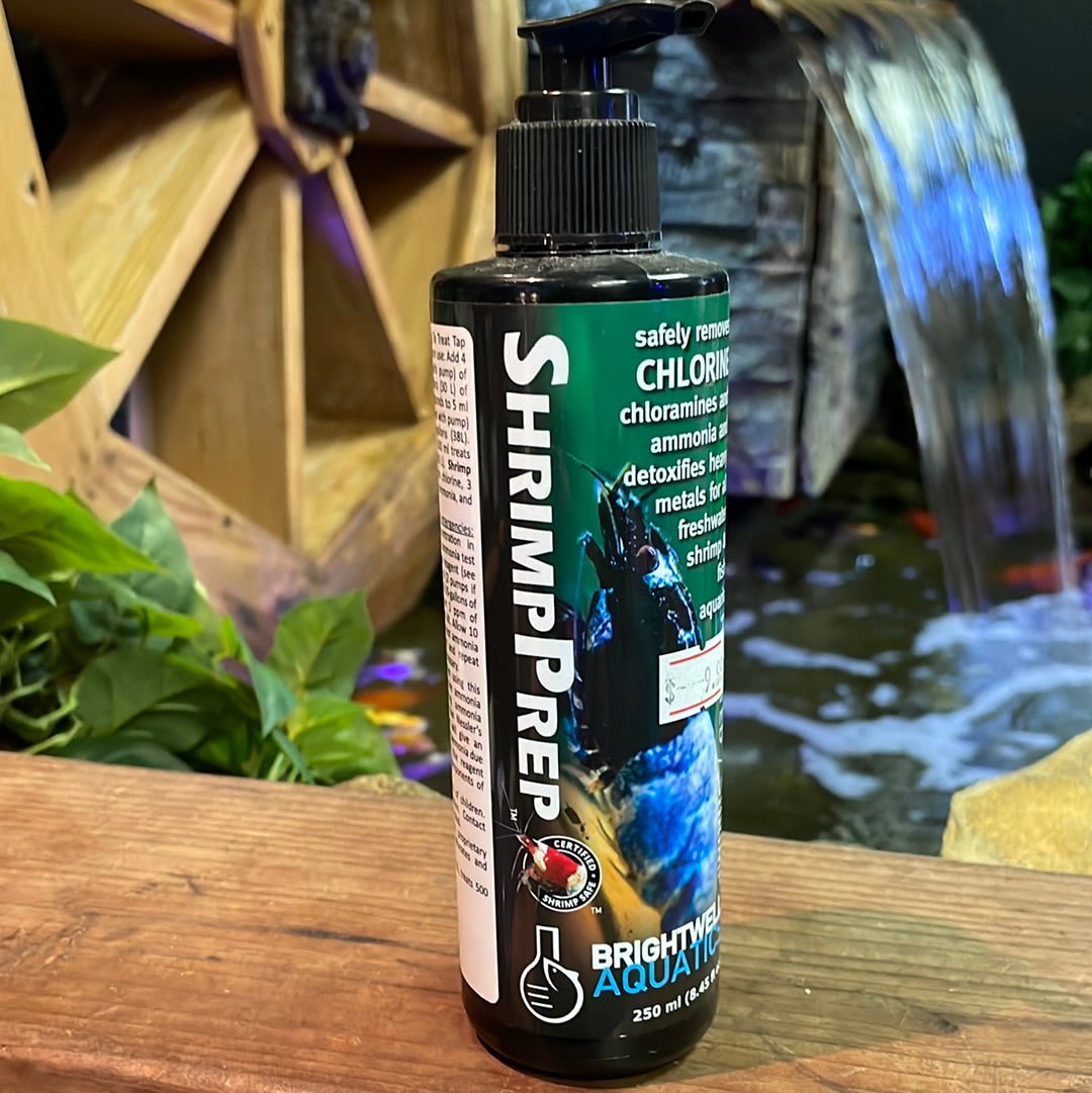 A bottle of Brightwell Shrimp Prep 250ml, a saltwater dry good, placed on a wooden surface with a aquatic environment in the background.