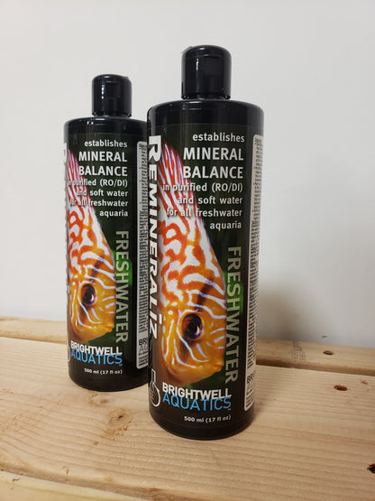 Two bottles of Brightwell Aquatics aquarium water treatment products placed on a wooden surface.